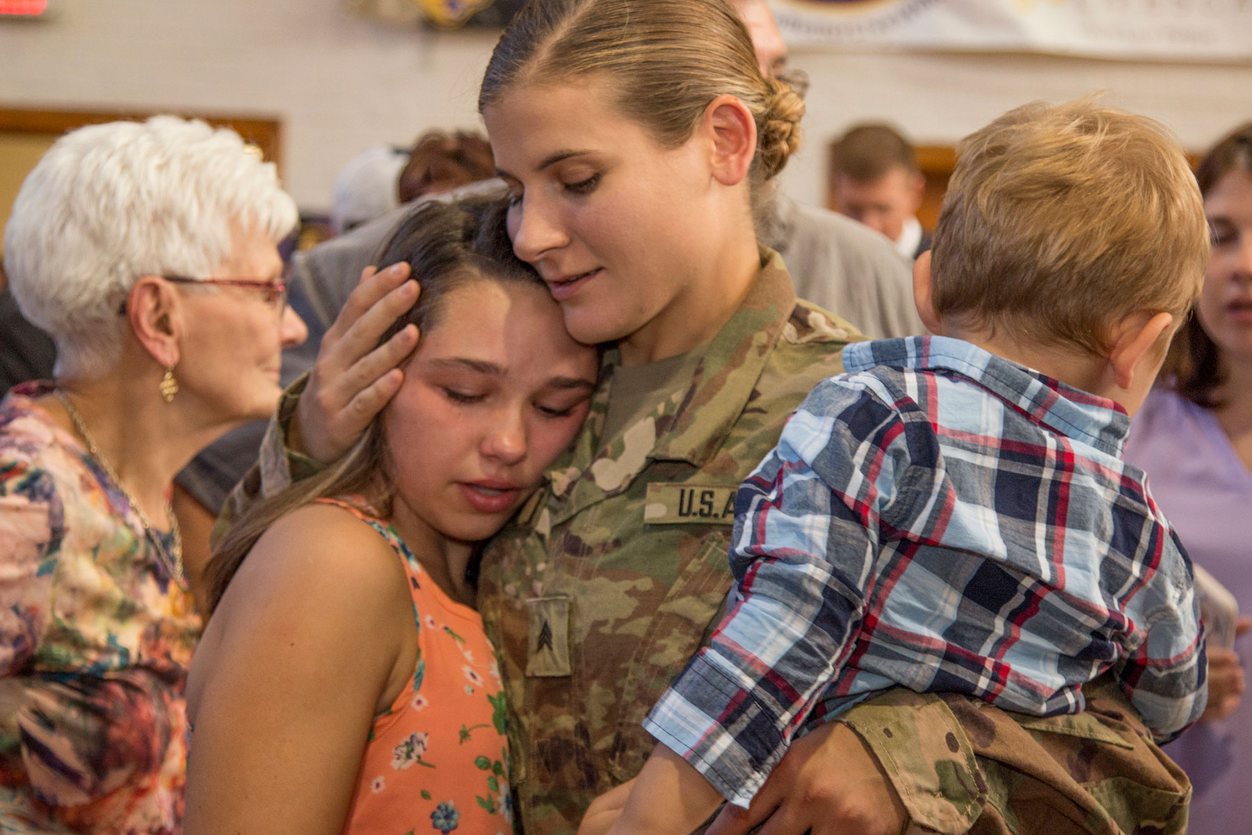 Sgt. Allison Catic, Company A, 248th Aviation Support Battalion, 67th Troop Command, Iowa Army National Guard, embraces her children following the unit’s send-off ceremony at Cedar Falls, Iowa, on Sept. 29, 2017. (U.S. Army National Guard/Tawny Schmit)