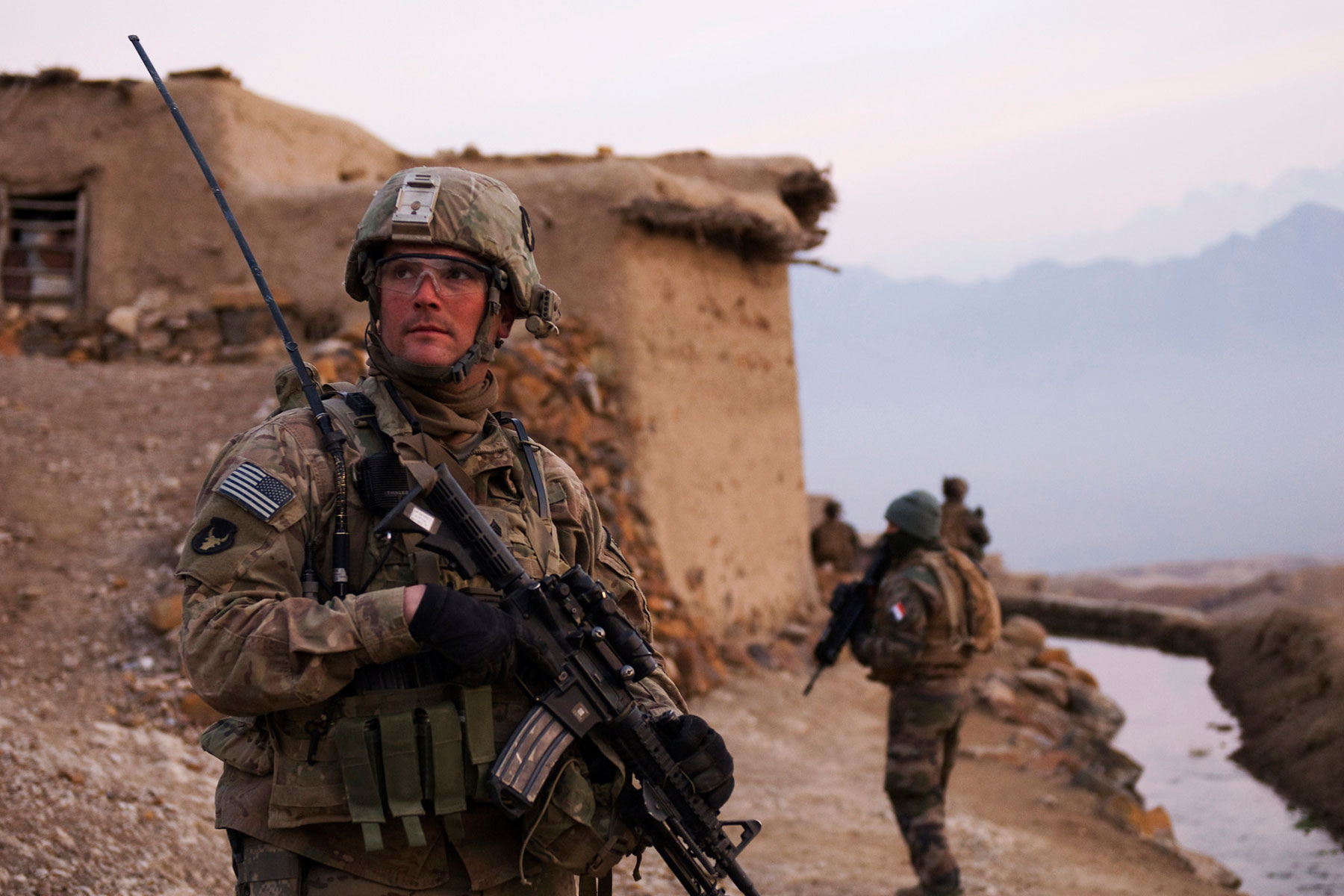 U.S. Army Sgt. Robert Streeter of Newton, Iowa, and a Soldier with Troop B, 1st Squadron, 113th Cavalry Regiment, Task Force Redhorse, scans a nearby hilltop during a search of the Qual-e Jala village. (U.S. Army/Ashlee Lolkus)