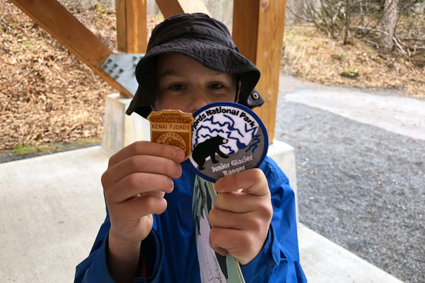 A military kid shows off his patch and Junior Ranger badge earned during a Kids to Parks Blue Star Families event at Kenai Fjords National Park, Alaska (Military.com/Amy Bushatz)