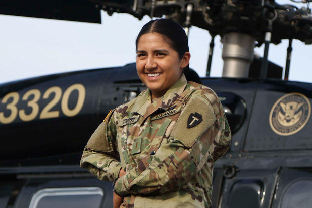 Army 2nd Lt. Liliana Chavez poses in front of a helicopter at McAllen International Airport, Texas, April 24, 2018. Chavez, who grew up in humble circumstances, today flies UH-60 Black Hawk and UH-72A Lakota helicopters for the Texas Army National Guard. (Army photo/Nadine Wiley De Moura)