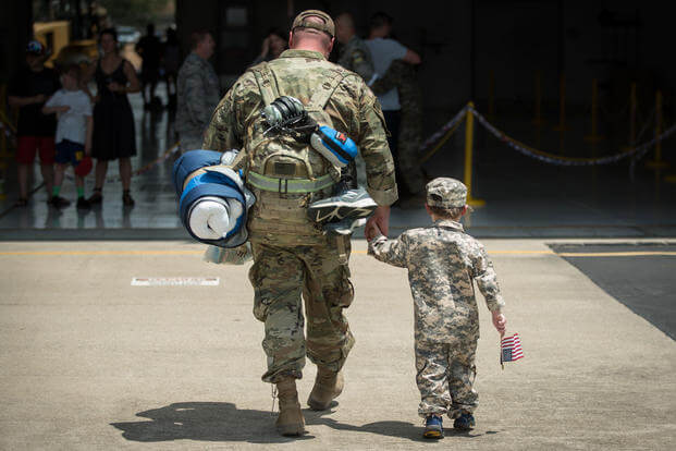 A boy reunites with his father during a homecoming ceremony at the Kentucky Air National Guard Base in Louisville, Kentucky. (U.S. Air National Guard/Dale Greer) 