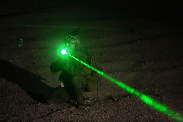 A student with Infantry Officers Course 4-14, provides security for the extraction of American non-combatant role players after the long-range vertical insertion of a Company Landing Team during Exercise Talon Reach IV at Range 220, Sept. 19, 2014. The prospective infantry officers pointed a non-lethal laser at simulated protesters, which can cause nausea and disorientation. (U.S. Marine Corps photo/Lauren A. Kurkimilis) 