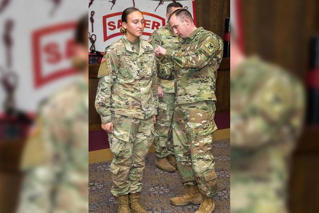 Sergeant Hailey Falk, combat engineer with 39th Brigade Engineer Battalion, 2nd Brigade Combat Team, 101st Airborne Division, receives her Sapper tab from Capt. Timothy Smith during the Sapper Leader Course graduation ceremony Dec. 7, 2018, at Fort Leonard Wood, Missouri. (Photo: U.S. Army)