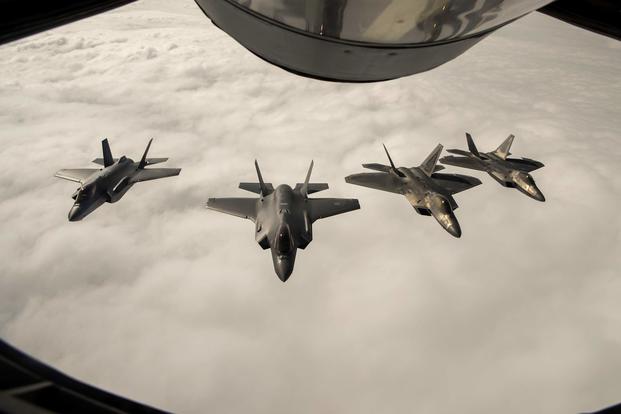 Two F-22 Raptors from the 95th Fighter Squadron, 325th Fighter Wing, based at Tyndall Air Force Base, Fla., fly in formation and conduct training operations with two Royal Norwegian air force F-35A Lightning II aircraft during an air refueling over Norway on Aug. 15, 2018.  (U.S. Air Force photo by Senior Airman Preston Cherry)