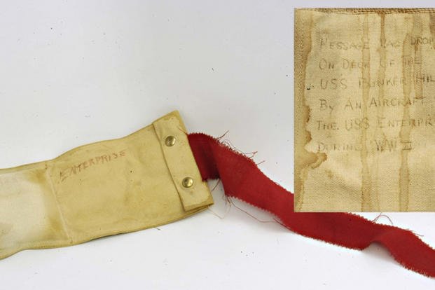 Photo shows an actual message container called a bean-bag used to deliver messages from an aircraft to the ship during WWII. In order for airborne pilots to safely communicate with the ship, each plane was equipped with several bean-bags in which a note could be placed and dropped to the deck of the carrier as the pilot slowly flew over. (Photo provided by the Naval Aviation Museum)