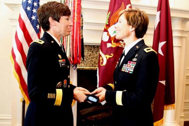 Maj. Gen. Maria Barrett presents Brig. Gen. Paula Lodi a beret with one-star rank insignia. (US Army)