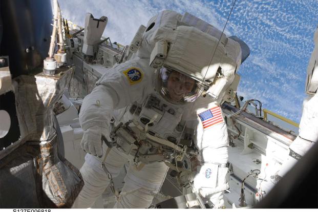 Army astronaut Col. Tim Kopra maneuvers himself within the space shuttle Endeavor’s cargo bay. (Photo Credit: NASA)