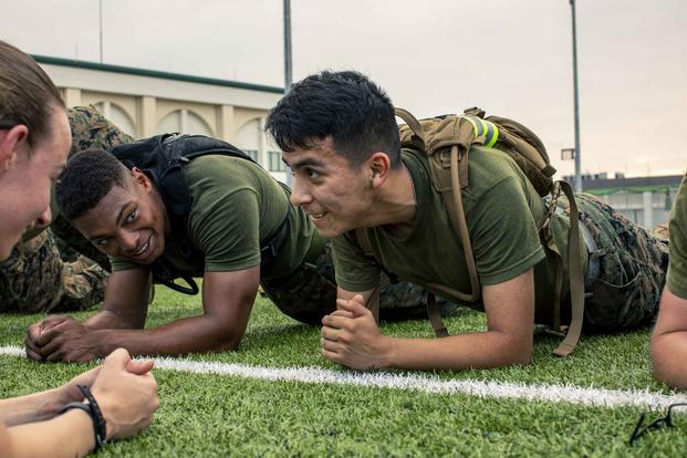 U.S. Marine Corps Lance Cpl. Joshua Davis, left, and Lance Cpl. Zachary Ballesteros, both with Headquarters and Headquarters Squadron, hold planks during a squadron physical training event at Marine Corps Air Station Iwakuni, Japan, on July 26, 2019. (U.S. Marine Corps/Lance Cpl. Lauren Brune)