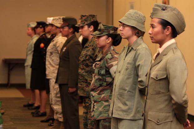 Marines display the different uniforms women have worn since World War I during the Women’s History Month fashion show. 
