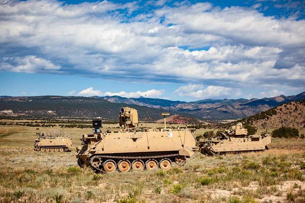 A Mission Enabling Technologies-Demonstrator nd two Robotic Combat Vehicles maneuver through a Fort Carson training area 