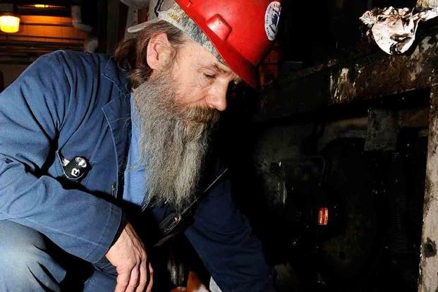 Bill Ball, 354th Civil Engineer Squadron mechanic, removes a gearbox from a boiler at the Central Heat and Power Plant. (Staff Sgt. Jim Araos/U.S. Air Force photo)