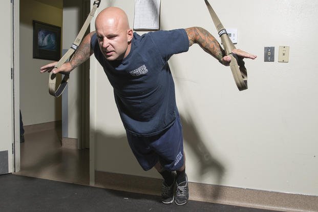 A firefighter works with the TRX suspension system.
