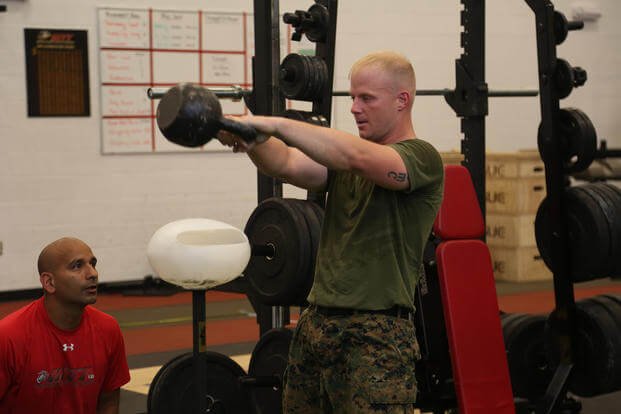 A Marine works out doing kettlebell swings.