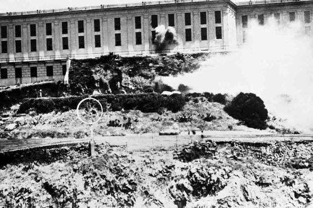 A U.S. Marine throws a grenade at prisoners behind the walls of Alcatraz Federal Penitentiary, May 4, 1946. (National Park Service)