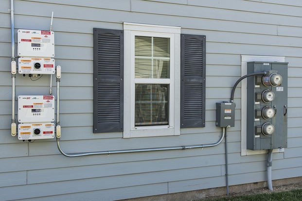 Electricity generated by photovoltaic panels is directed to inverter units prior to entering the electrical grid in a housing community at Dover Air Force Base, Delaware.
