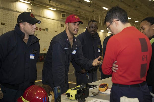 Electrician's Mate 1st Class Michael McFadden speaks with Professional Apprenticeship Career Tracks (PACT) sailors during a job mentorship fair on the USS Gerald R. Ford.