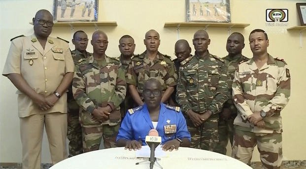 Col. Maj. Amadou Abdramane sits in front of military men in in Niamey, Niger.