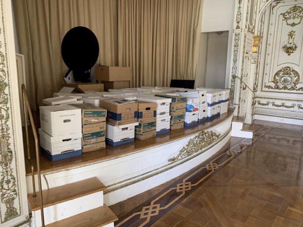 boxes of records being stored on the stage in the White and Gold Ballroom at Trump's Mar-a-Lago estate
