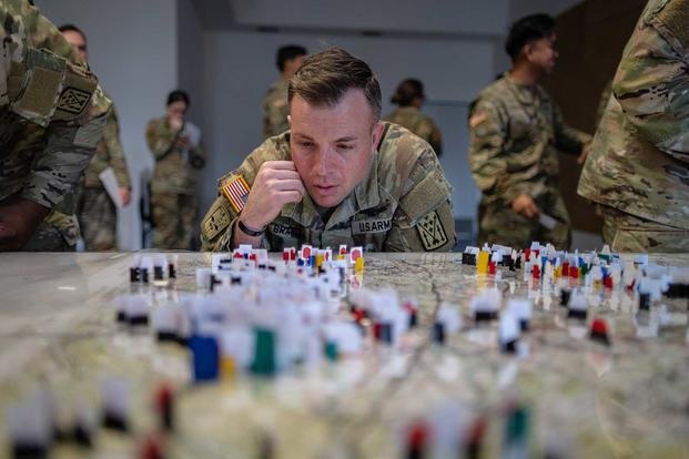 U.S. Army Chief Warrant Officer 2 Ran Brand, an air missile defense system integrator, analyzes the table for his next move during the 2024 Kriegsspiel Event at Ansbach, Germany. (Sgt. Scyrrus Corregidor/U.S. Army photo) U.S. Army Chief Warrant Officer 2 Ran Brand, an air missile defense system integrator, analyzes the table for his next move during the 2024 Kriegsspiel Event at Ansbach, Germany.
