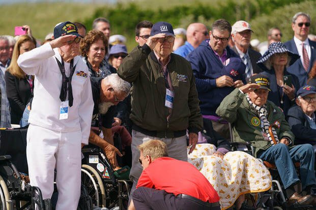U.S. WWII veterans stand and salute during the playing of the National Anthem at the Utah Beach D-Day Ceremony at Utah Beach, Normandy, France, June 6, 2024. (Keith Thornburgh/U.S. Army) U.S. WWII veterans stand and salute during the playing of the National Anthem at the Utah Beach D-Day Ceremony at Utah Beach, Normandy, France