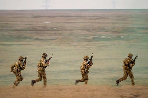 FILE- Servicemen run during the Steadfast Dart 2025 exercise, involving some 10,000 troops in three different countries from nine nations, representing the largest NATO operation planned this year, at a training range in Smardan, eastern Romania, Wednesday, Feb. 19, 2025. (AP Photo/Vadim Ghirda, file) NATO US Europe