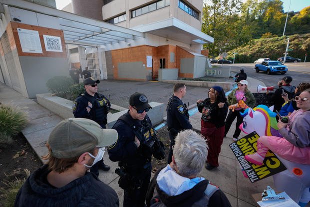 Law enforcement officers talk with protesters outside a United States Immigration and Customs Enforcement (ICE) facility in Portland, Ore., Monday, Oct. 20, 2025. (AP Photo/Jenny Kane) Oregon Immigration
