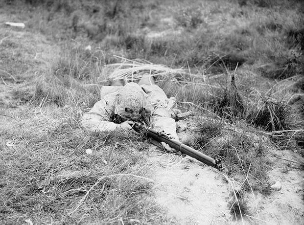 Lovat Scout in prone firing position, dressed in sniper camouflage, Bisley, Surrey, 9 July 1940.