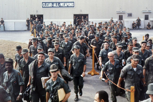 Personnel destined to return to the United States wait at the Bien Hoa Air Terminal, Vietnam, for a flight home.