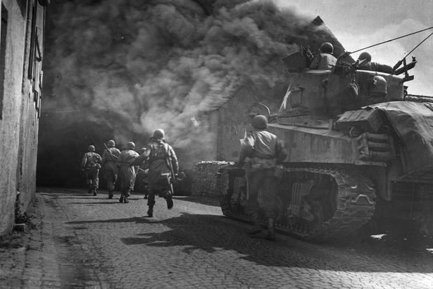 U.S. Third Army runs through smoke-filled streets in Wernberg, Germany. (National Archives photo)