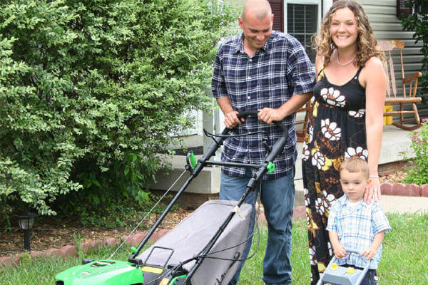 Military family mowing lawn.