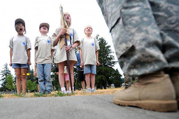 Military children shout "Fire in the hole!" in response to their commander, Sgt. Russell Ho's call to attention at the 2010 deployment camp at Joint Base Lewis-McChord.  (Caption: Photo Credit: Ingrid Barrentine)