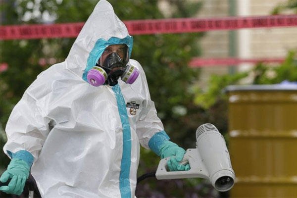 A hazmat worker clean outside the apartment building of a hospital worker, Sunday, Oct. 12, 2014, in Dallas. (LM Otero/AP Photo)