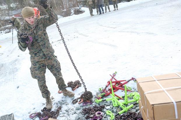 A Marine with 2nd Marine Expeditionary Brigade prepares the tie down chains shortly before transporting multiple vehicles by rail at Hell Station in Hell, Norway Feb. 12, 2016. (Photo: Cpl. Dalton Precht)