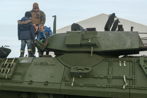 A Marine with 2nd Marine Expeditionary Brigade shows local children around a light armored vehicle at Hell Station in Hell, Norway, Feb. 12. (Photo: Cpl. Dalton Precht)