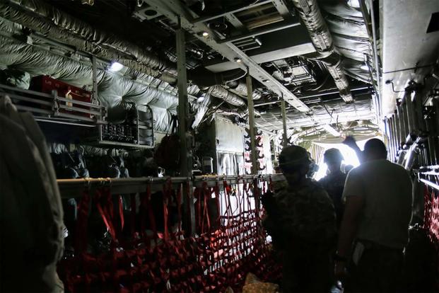 A Variety of U.S. and coalition military personnel board a C-130 for transport. (Photo: Oriana Pawlyk/Military.com)
