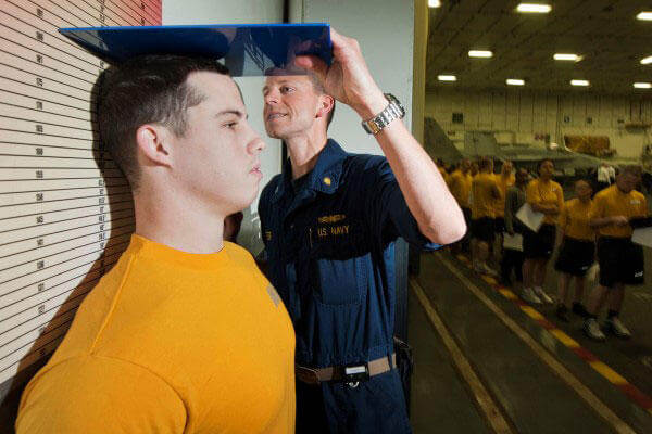 Command Fitness Leader Lt. Bradley Lester measures a Sailor's height while conducting the body composition assessment. (U.S. Navy photo by Mass Communication Specialist 2nd Class James R. Evans)