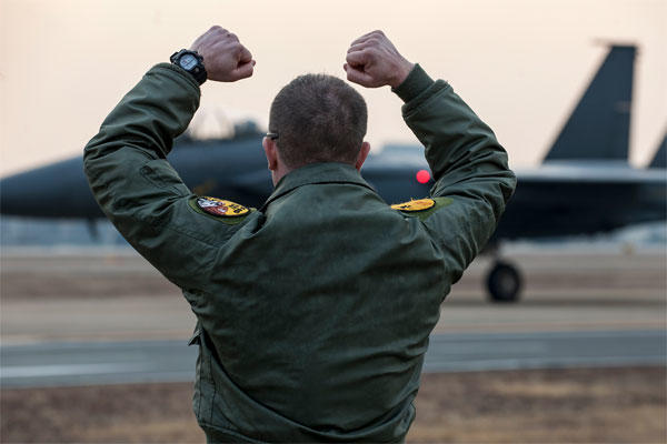 Maj. Dean Laansma gives the 80th Fighter Squadron "Crush 'em" gesture to an F-15K Slam Eagle as it taxis during exercise Buddy Wing 15-2 Feb. 5, 2015, at Daegu Air Base, South Korea. (U.S. Air Force photo/Senior Airman Katrina Heikkinen)