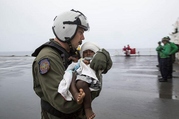A toddler is rescued from the sea in the arms of a U.S. Navy sailor after the 18-month girl spent more than 24 hours at sea. (Source: U.S. Navy)