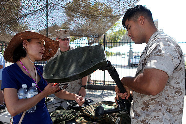 An explosive ordnance disposal Marine explains how a metal detector works to an onlooker during San Diego Fleet Week 2015 at Naval Base Coronado, Calif., Sept. 20, 2015. (U.S. Marine Corps/Sgt. Laura Gauna)