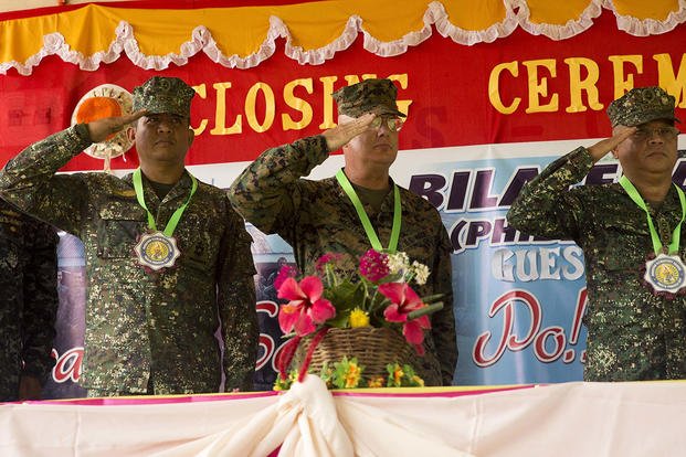 U.S. and Philippine service members salute at the ribbon cutting ceremony Oct. 8, in Puerta Princesa, during Amphibious Landing Exercise 2015. (Photo By: Lance Cpl. Robert D. Williams Jr)