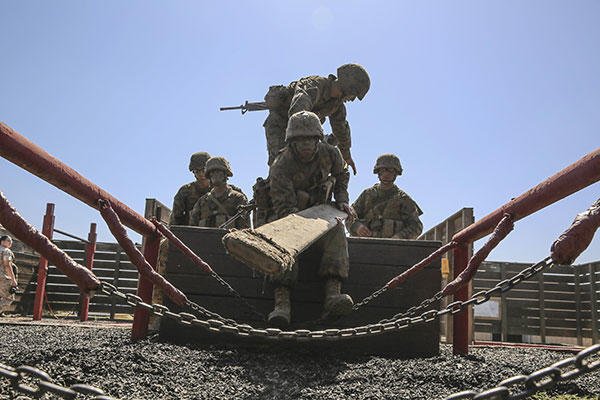 Marine Corps Pfc. Mason A. Davis lays a board across a chain bridge during the 12 Stalls event at Edson Range, Marine Corps Base Camp Pendleton, Calif., Sept. 23, 2015. (U.S. Marine Corps/Cpl. Jericho Crutcher)