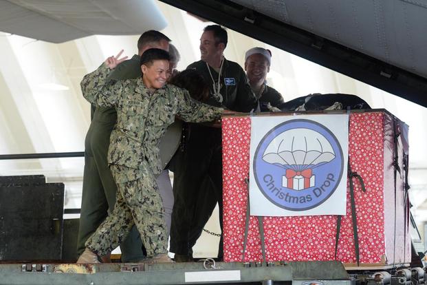 Rear Adm. Babette Bolivar counts down before pushing a crate containing donated goods into a C-130 Hercules during the Christmas Drop Push Ceremony Dec. 8, 2015, at Andersen Air Force Base, Guam. (Photo: Staff Sgt. Benjamin Gonsier)