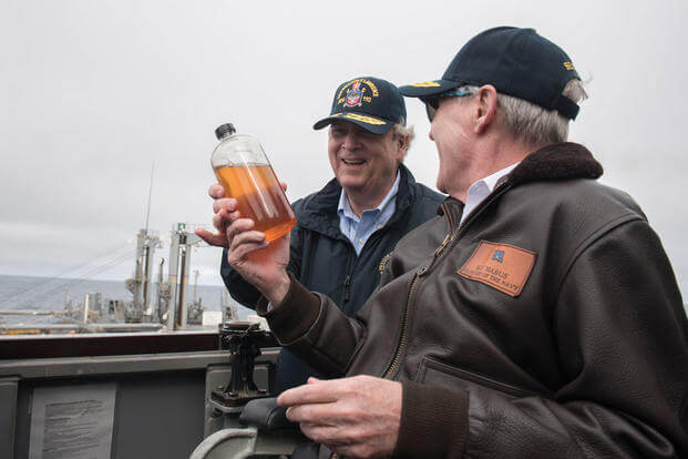 Secretary of the Navy Ray Mabus shows Secretary of Agriculture Tom Vilsack a fuel sample of alternative fuel aboard the guided-missile destroyer USS William P. Lawrence. (Photo: Mass Communication Specialist 2nd Class Armando Gonzales)