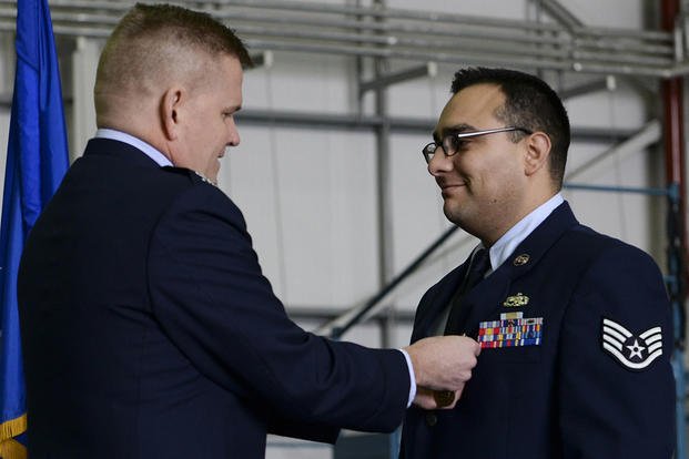 Col. Thomas D. Torkelson, the 100th Air Refueling Wing commander, presents Staff Sgt. Vicente Gomez with the Airman’s Medal during a ceremony on Royal Air Force Mildenhall, England. (U.S. Air Force/Senior Airman Victoria H. Taylor)