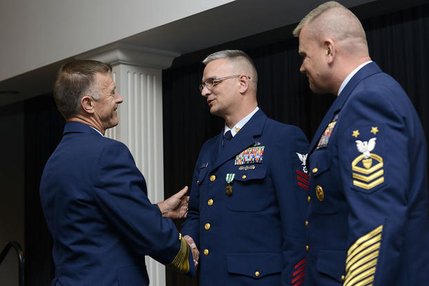 Adm. Paul Zukunft and Coast Guard Reserve Force Master Chief Eric Johnson congratulate PO1 Wilton Terry after presenting him with a Commendation Medal during the 2015 Coast Guard Enlisted Persons of the Year Banquet. (U.S. Coast Guard/CPO Nick Ameen)