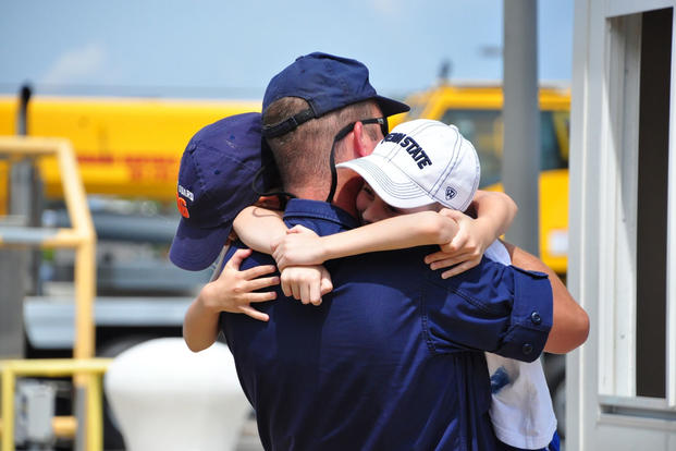 A crewmember from the Coast Guard Cutter Vigorous embraces his children July 11, 2016, in Virginia Beach, Virginia. (Photo: Petty Officer 1st Class Melissa Leake)