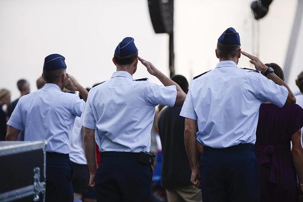 Airmen salute as the colors are presented during a wreath-laying ceremony. (Air Force photo/Tech. Sgt. Joshua L. DeMotts)