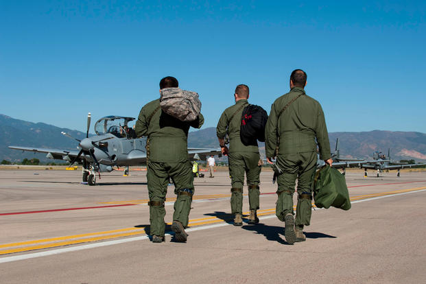 Two pilots from the 81st Fighter Squadron out of Moody Air Force Base, Ga., and an Afghan pilot walk to several A-29B Super Tucanos to prepare for training Sept. 16, 2015, at Peterson Air Force Base, Colo. U.S. Air Force photo/Airman 1st Class Rose Gudex