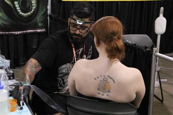 A member of the U.S. Navy sits for a tattoo with one of the many renowned tattoo artists who travel annually to the Pacific Ink & Art Expo, Blaisdell Exhibition Hall, Honolulu, Hawaii, Aug. 3, 2013. (U.S. Air Force photo by Tech. Sgt. Phyllis Keith)