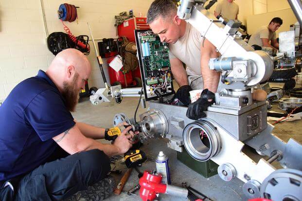 Technical Sgt. Dustin Frey, an EOD technician, assists Jack Caylor, Northrop Grumman Remotec robotic instructor, remove a difficult component during a maintenance class at Peterson Air Force Base, Colo., Aug. 17, 2016. Staff Sgt. Amber Grimm/Air Force